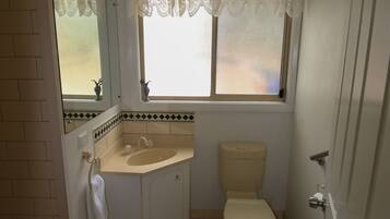 Un baño con inodoro, lavamanos y ventana.