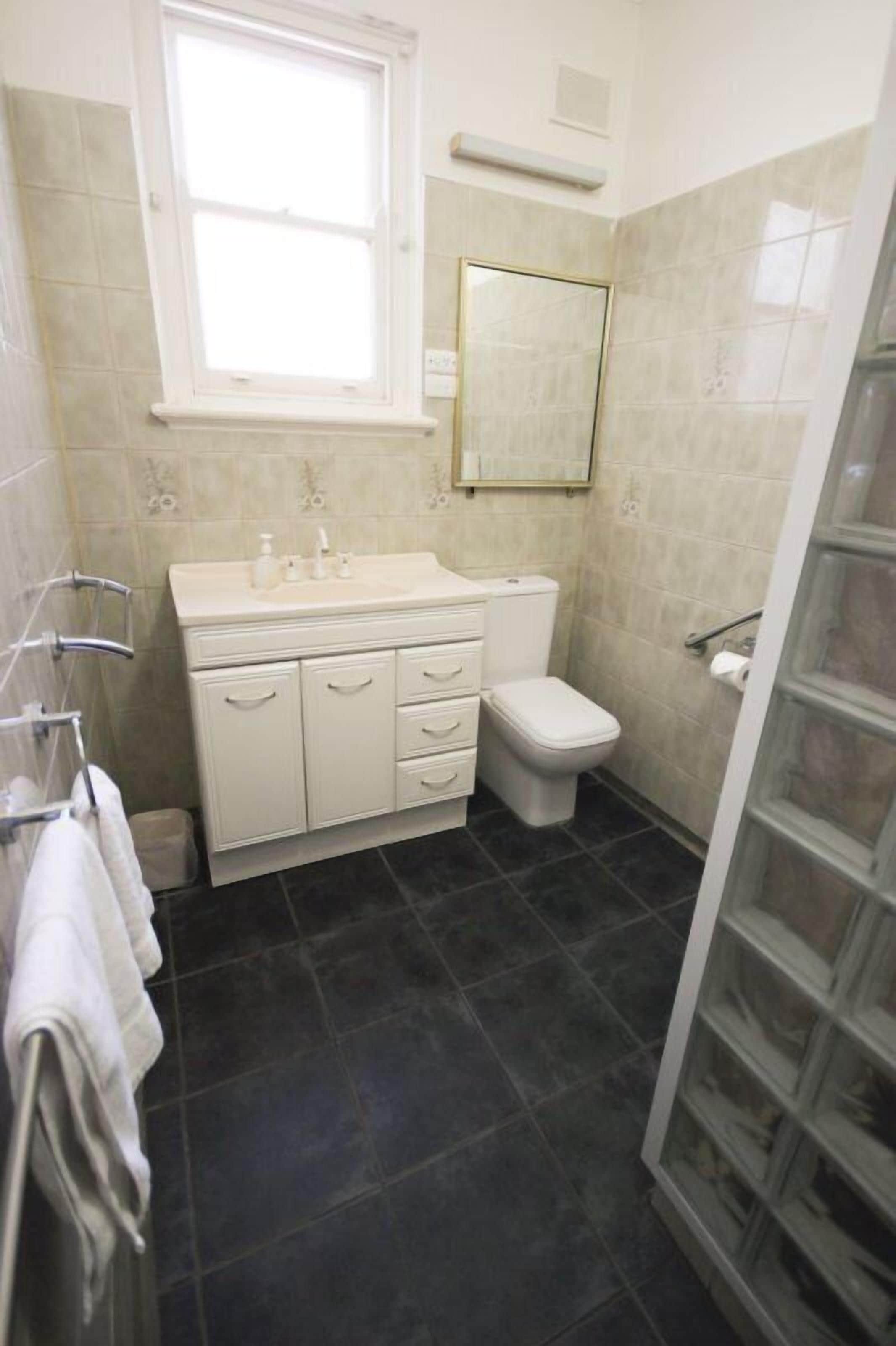 Un bagno piccolo e funzionale con lavandino bianco, water e box doccia in vetro.