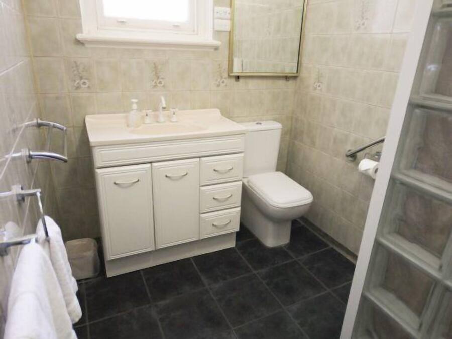 Un bagno piccolo e funzionale con lavandino bianco, water e box doccia in vetro.