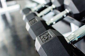 Primer pla d'una filera de halteres negres amb indicacions del pes.