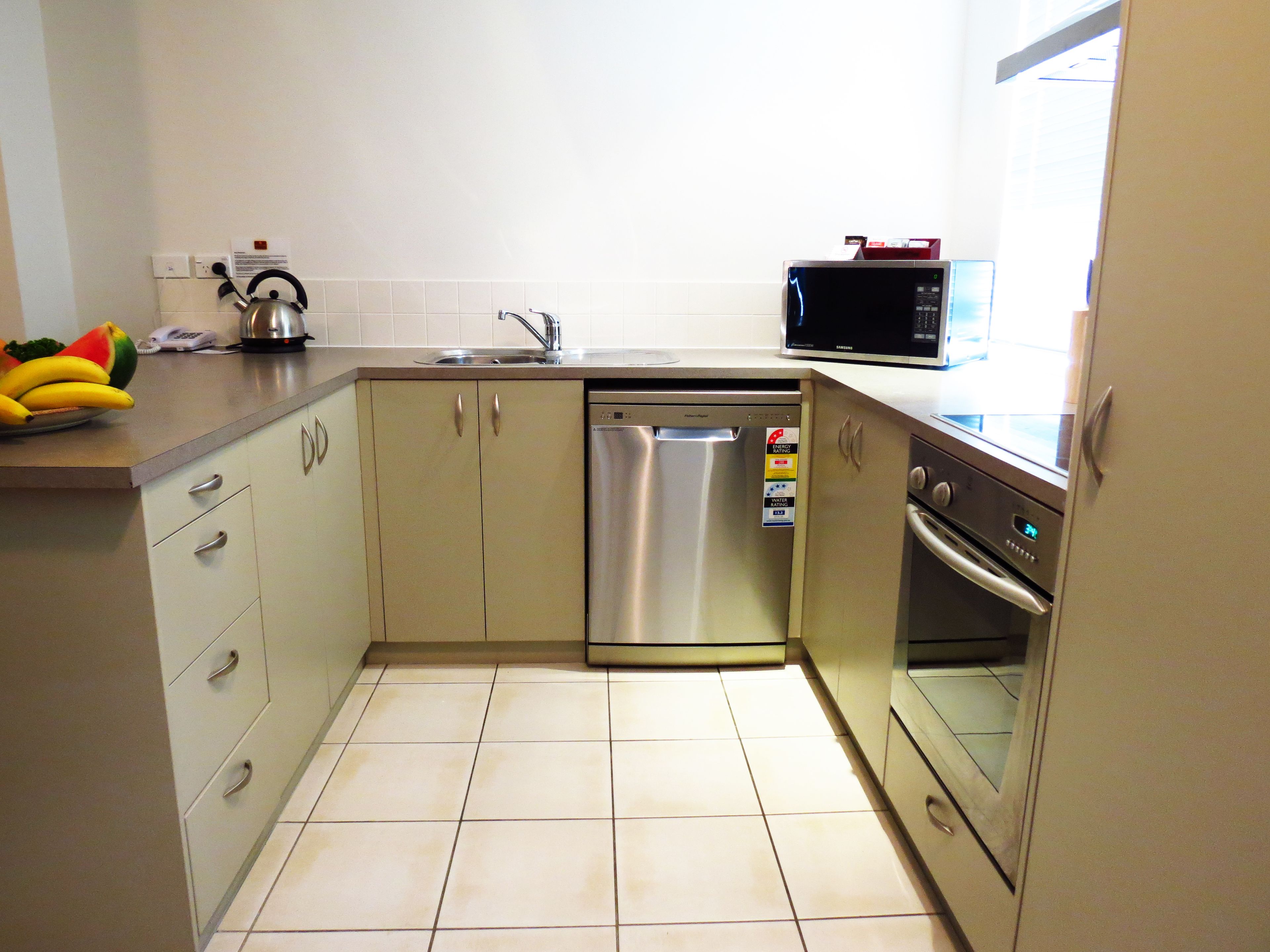 Cocina compacta con lavavajillas, horno y microondas.