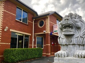 A brick building with a lion statue in front. - Sheffield Motor Inn (Sheffield)