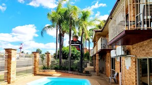 Una piscina con un muro de ladrillo y un letrero que dice 'Taroook Moto Inn'.