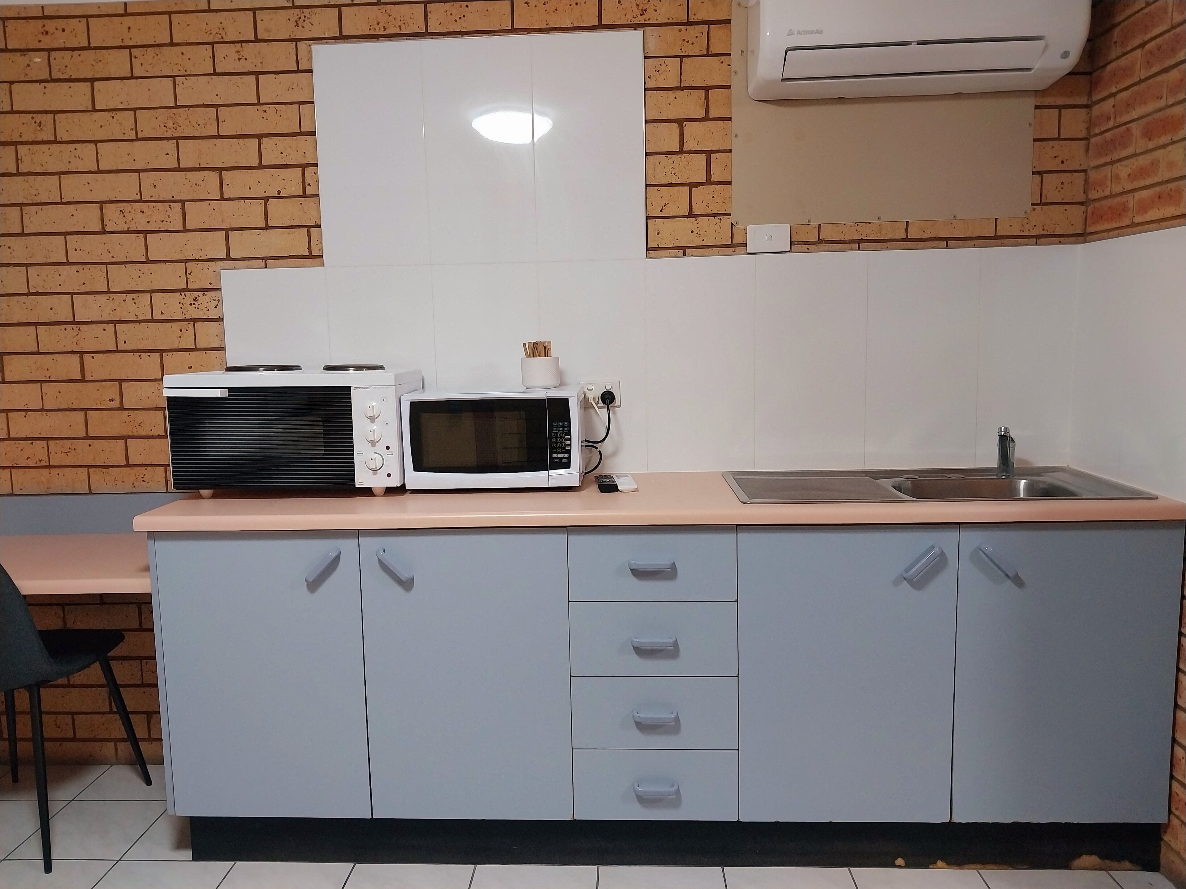 A kitchenette with a microwave, toaster, and sink.