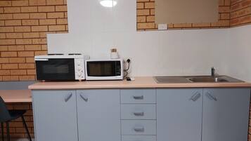 A kitchenette with a microwave, toaster, and sink.