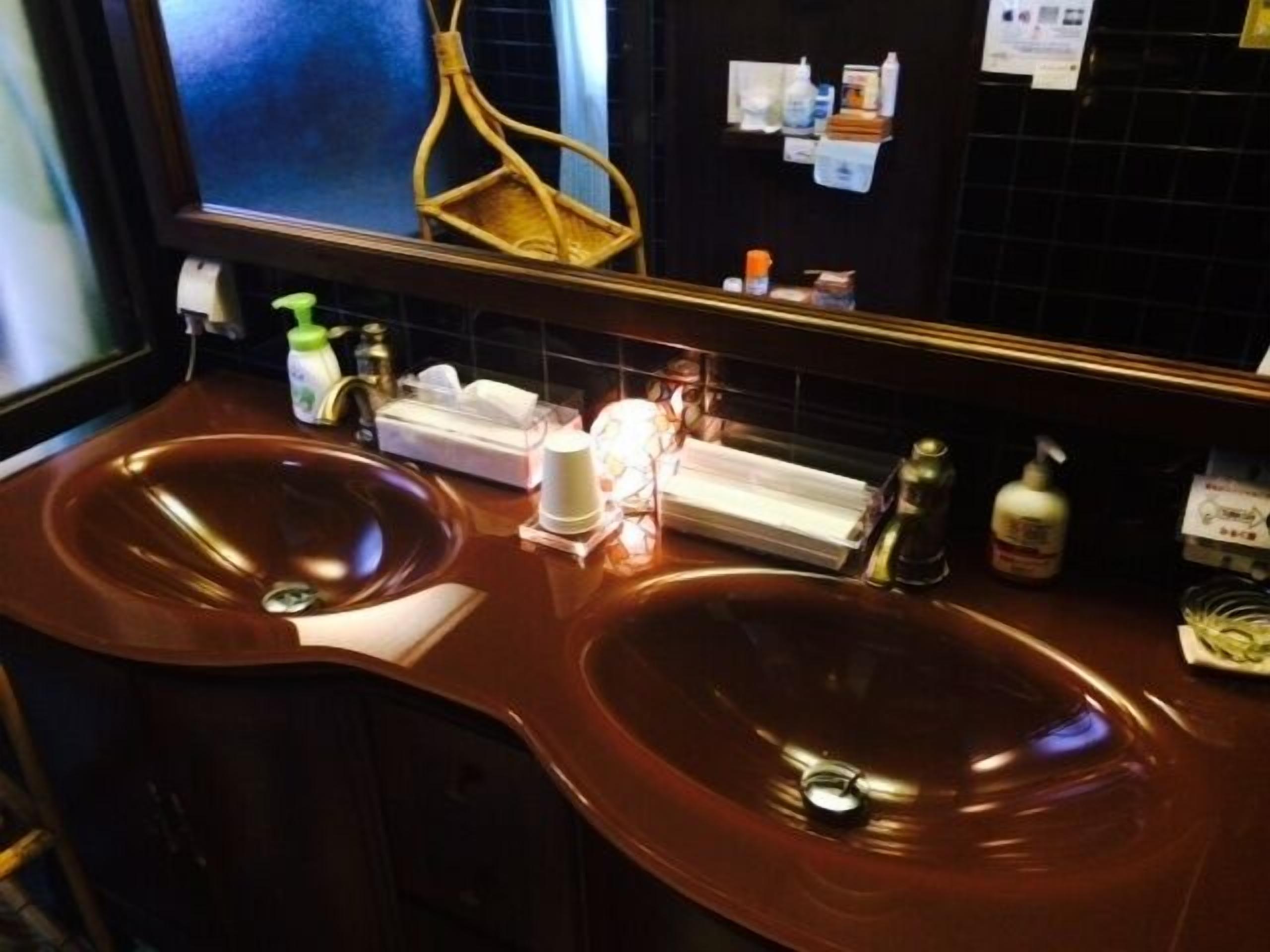 Een badkamer met twee wasbakken, een spiegel en toiletartikelen.