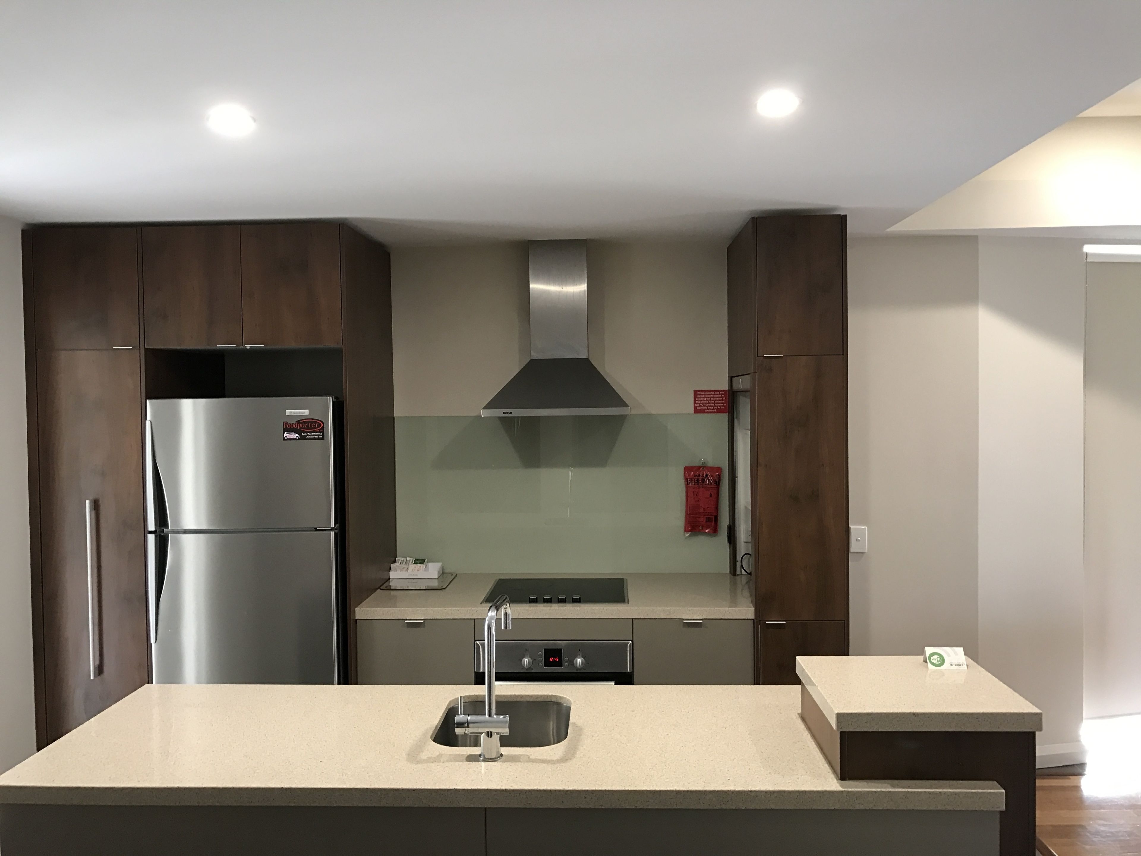 A modern kitchen with a stainless steel refrigerator, a built-in oven, and a gas stove.