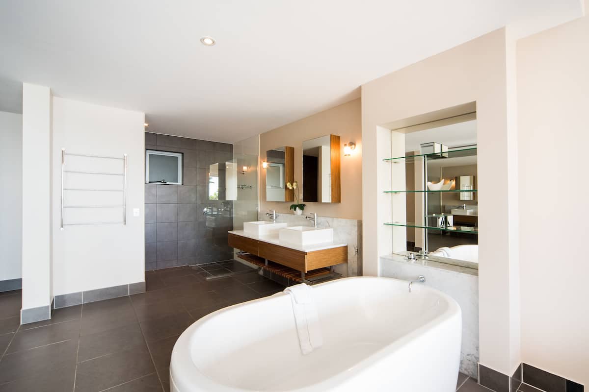Une salle de bain moderne avec une baignoire sur pieds, un meuble-lavabo double et une douche à paroi de verre.