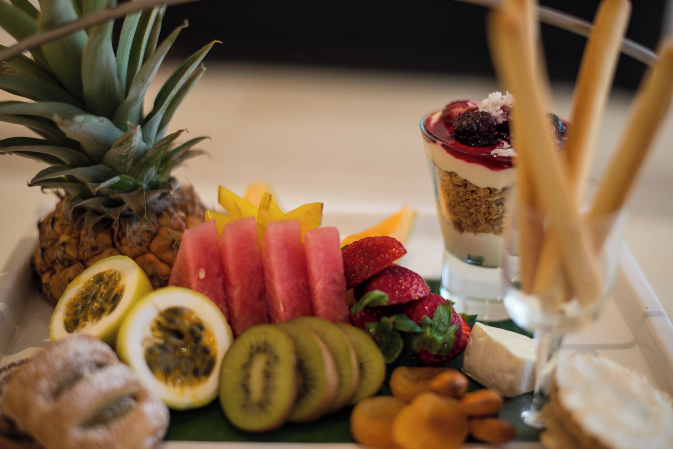 A fruit platter with various tropical fruits and a dessert.