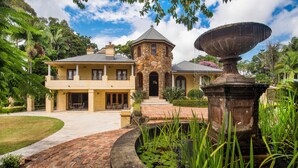 A large house with a stone tower, a brick pathway, and a fountain. - Abbie's Byron Bay Villa (Ewingsdale)