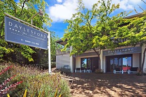 Alojamiento tipo spa en Daylesford, con letrero, mobiliario exterior y jardín.