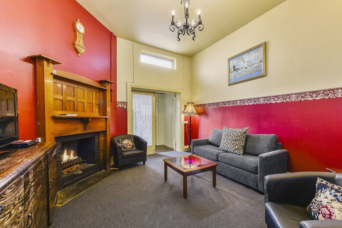A living room with a fireplace, a sofa, a coffee table, and a television.