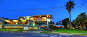 Welcome to this charming motel with a central entrance and beautifully manicured lawn.