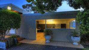 A modern house with a kitchen and dining area visible through a glass door. - Bermagui Motor Inn (Bermagui)