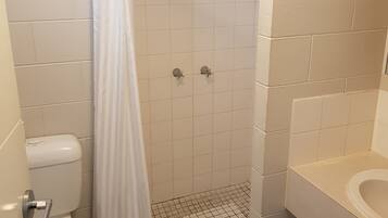 A bathroom with a shower, toilet, and sink.