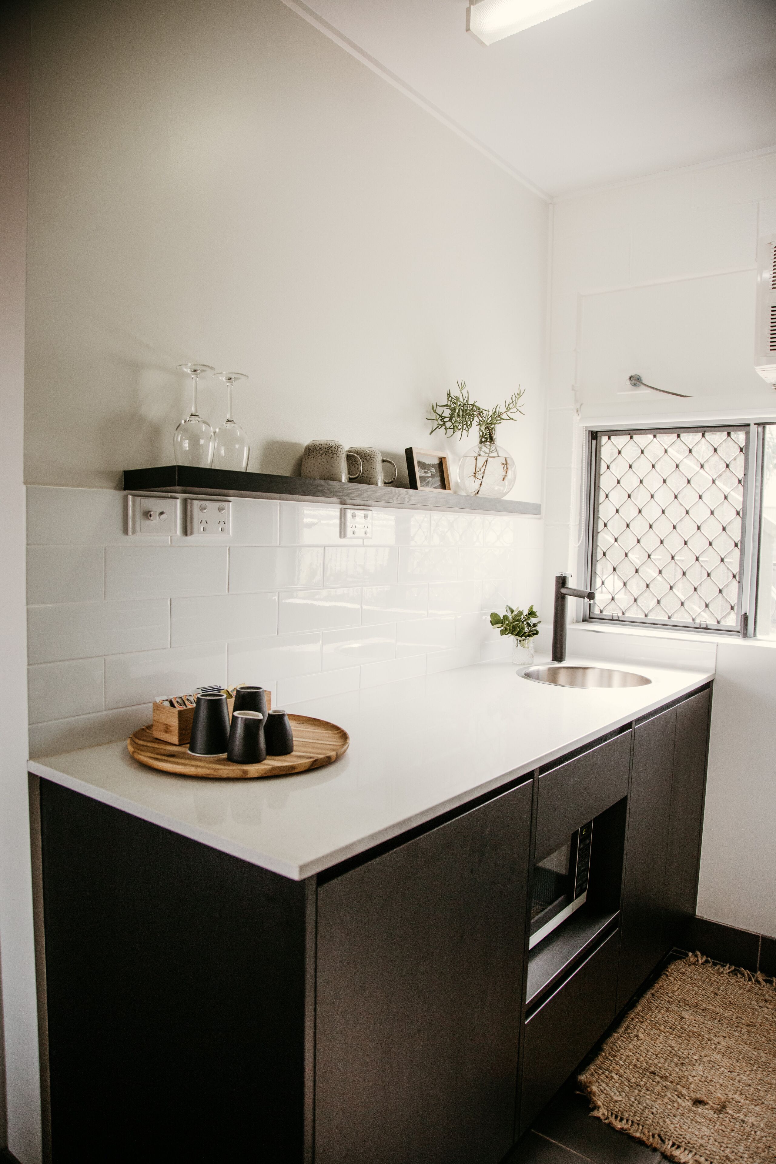 Una cocina moderna con una isla central, horno empotrado y ventana con vistas.