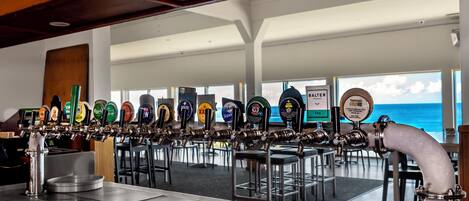 A bar with a beer tap system and a view of the ocean.