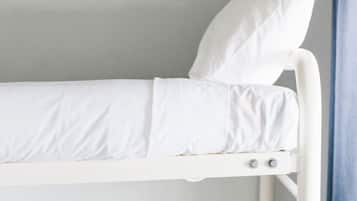 A bunk bed with white bedding and a pillow.