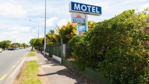 A motel sign with a 'Sunset Lodge' logo and a 'No Parking' sign. - Sunset Lodge Motel (Auckland)
