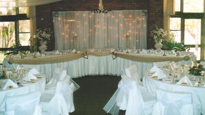 A banquet hall with round tables set for a formal event, featuring white tablecloths, gold accents, and floral centerpieces. - Kerang Valley Resort (Kerang)