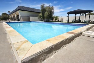 室外游泳池，池畔遮阳伞，日光浴躺椅