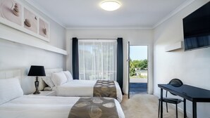 A hotel room with two beds, a desk, and a TV. - Kerang Valley Resort (Kerang)