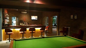 A pool table with a green felt surface, a bar area with stools, and a brick wall. - Kerang Valley Resort (Kerang)