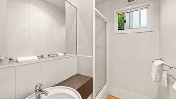 Une salle de bain moderne avec un lavabo, un miroir et un porte-serviettes.