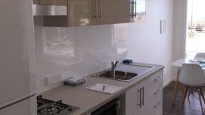 A modern kitchen with stainless steel appliances, a built-in oven, and a sink. - Brighton Beachfront Holiday Park (Kingston Park)