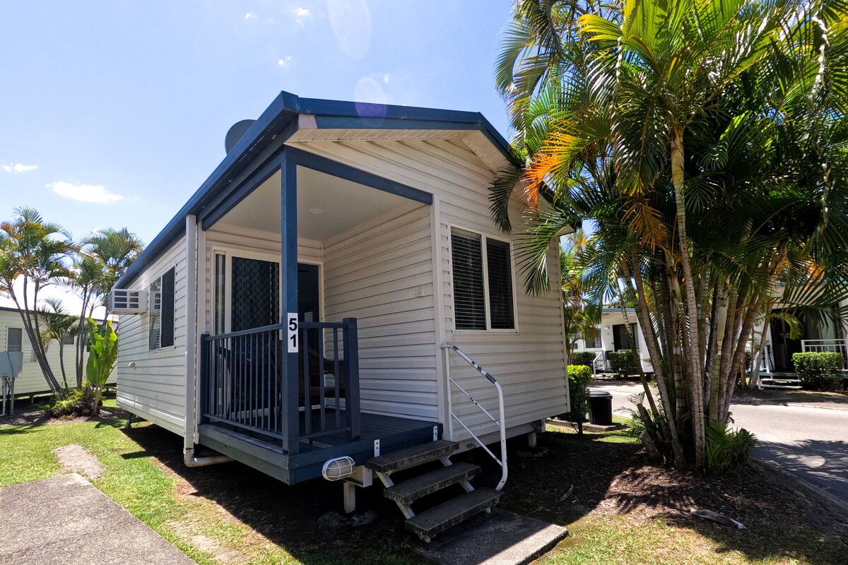 A mobile home with a porch, a small set of stairs, and a number sign '51'.