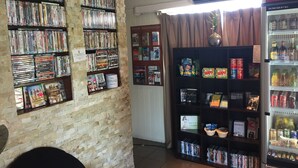 A room with a brick wall, a ceiling fan, a minibar, and a DVD player. - Country Plaza Motor Inn (West Mackay)