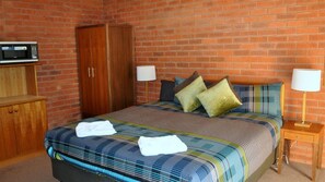 Cortinas blackout, tabla de planchar con plancha y ropa de cama