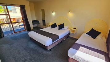 Een hotelkamer met twee bedden, een groot raam met uitzicht en een balkon met een leuning.