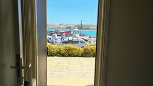 A doorway leading to a parking area with boats and a clear view of the sea. - On The Terrace Stanley (Stanley)