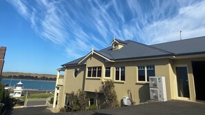 A two-story building with a flat roof, a balcony, and a view of the sea. - On The Terrace Stanley (Stanley)