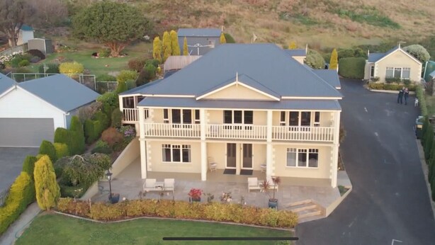 A two-story house with a balcony, a driveway, and a well-maintained lawn. - On The Terrace Stanley (Stanley)