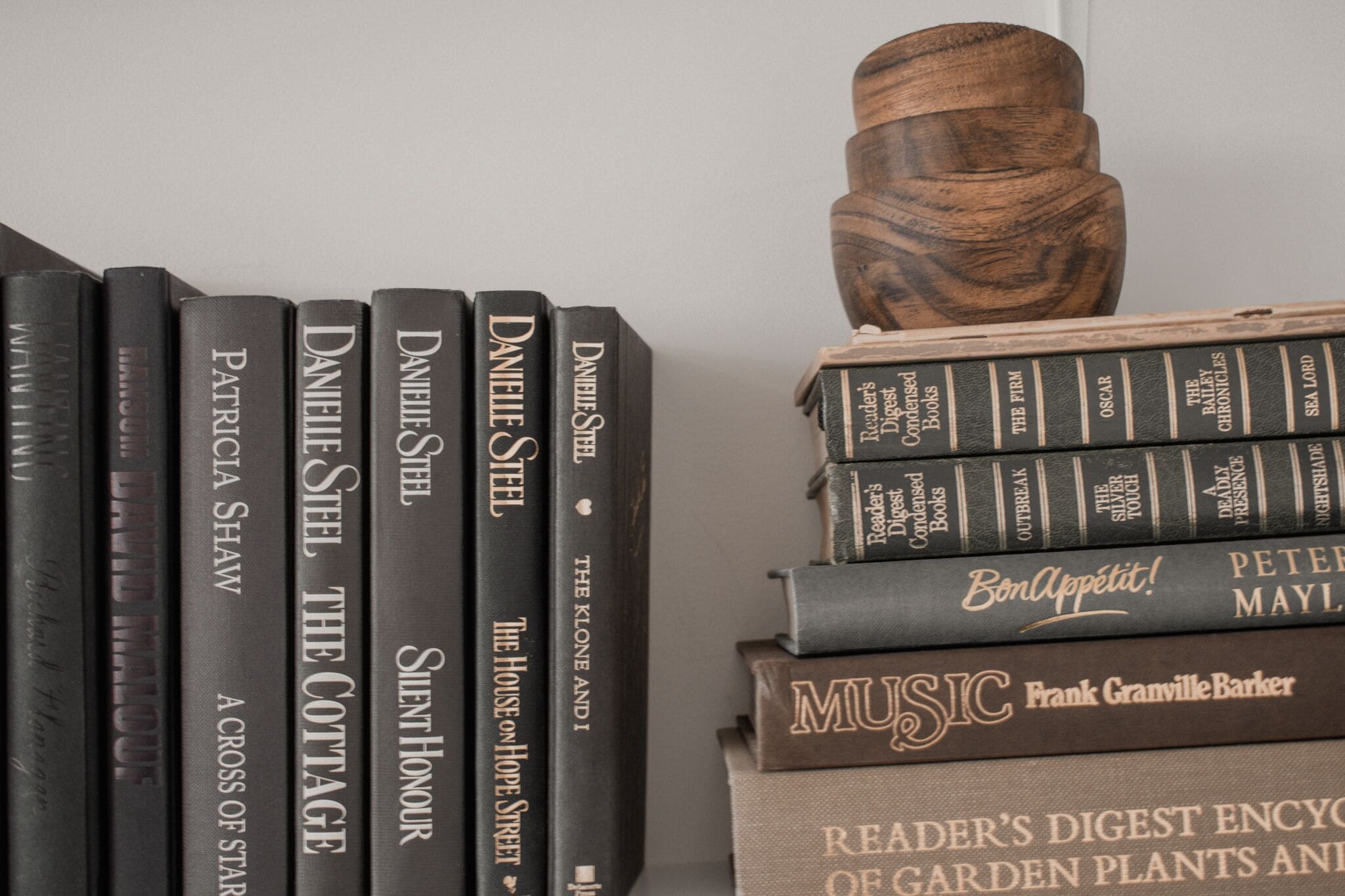 A bookshelf with books and a decorative wooden object.