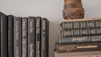 A bookshelf with books and a decorative wooden object.