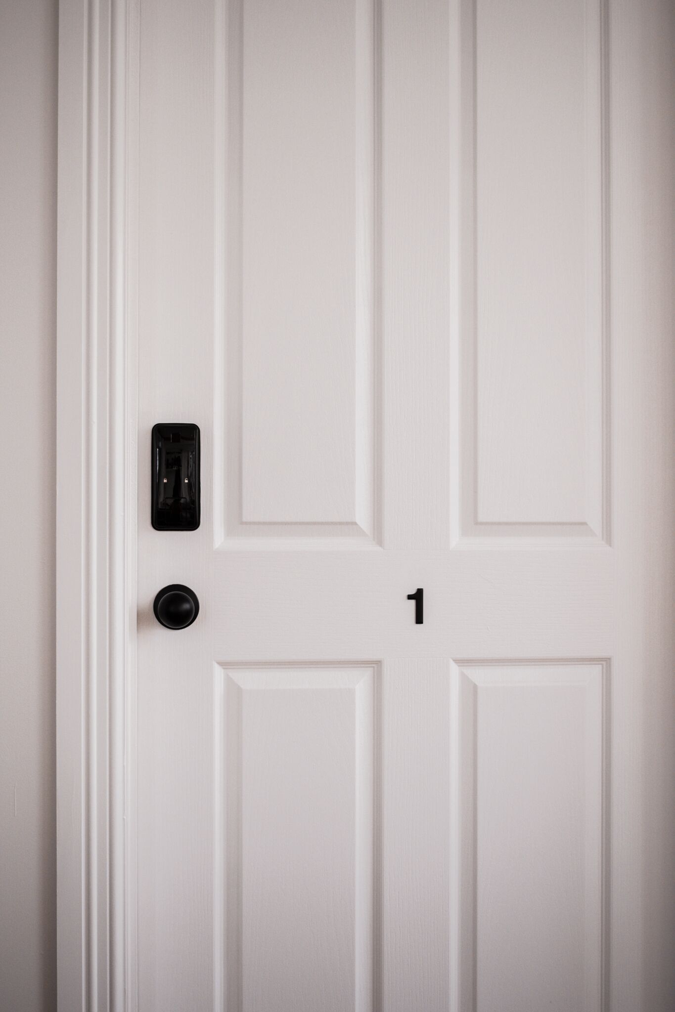 Una puerta blanca con un portero automático y un timbre.