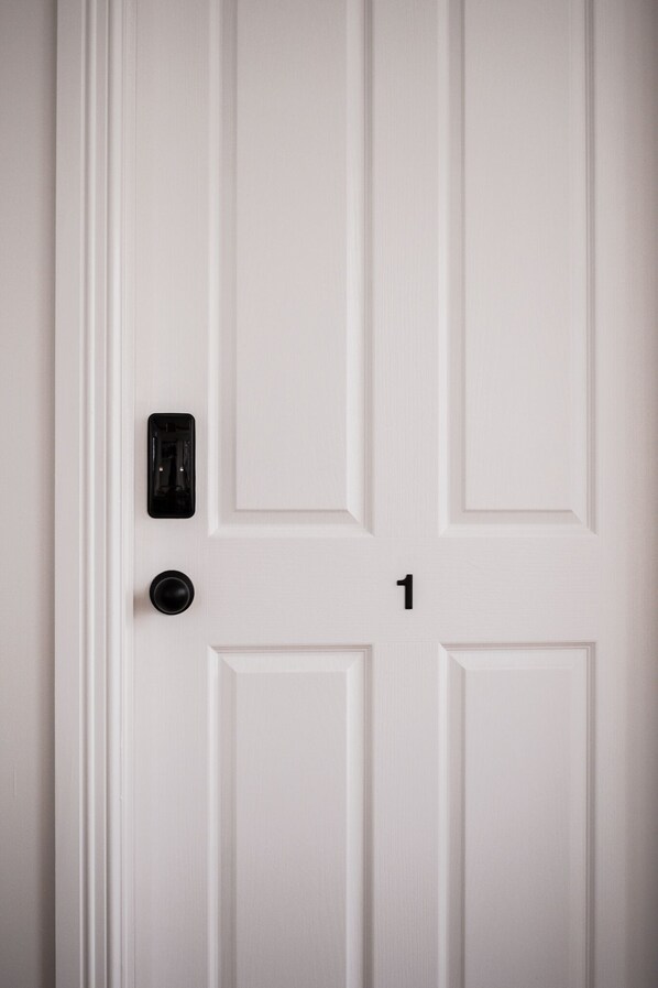 Una puerta blanca con un portero automático y un timbre.