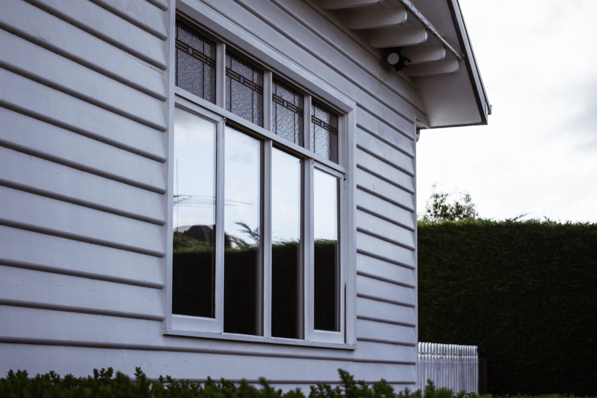 A house with a large window and a white exterior.