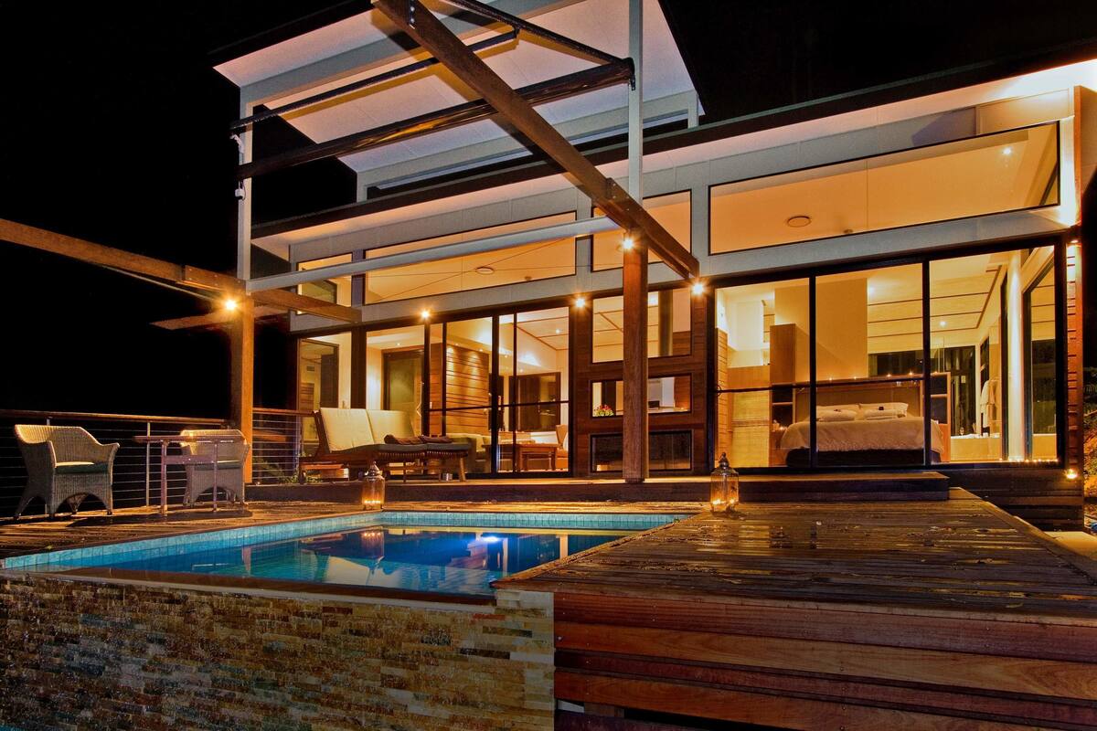Un hôtel moderne doté d’une piscine, d’un espace extérieur aménagé et d’un intérieur bien éclairé.