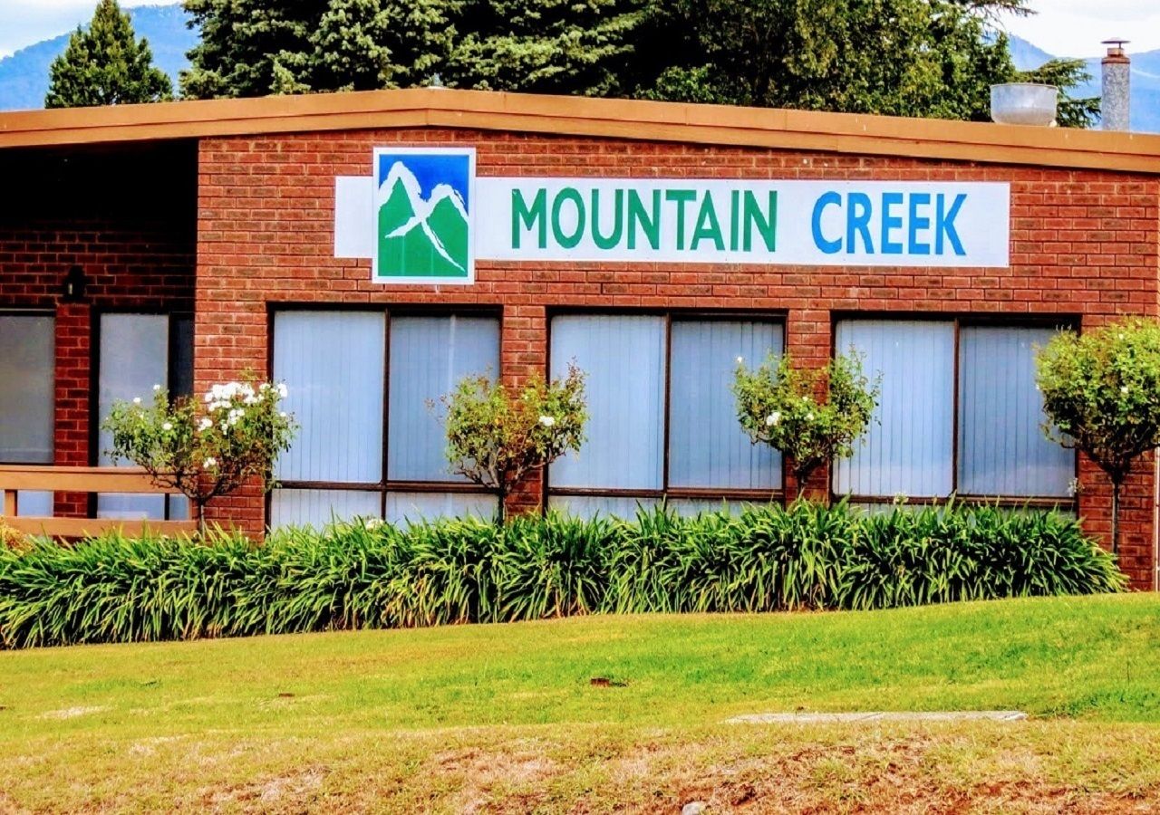 Un bâtiment sur lequel on peut lire l’inscription « Mountain Creek » et qui arbore un logo représentant des montagnes.