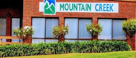 A building with a sign reading "Mountain Creek" and a logo of mountains.
