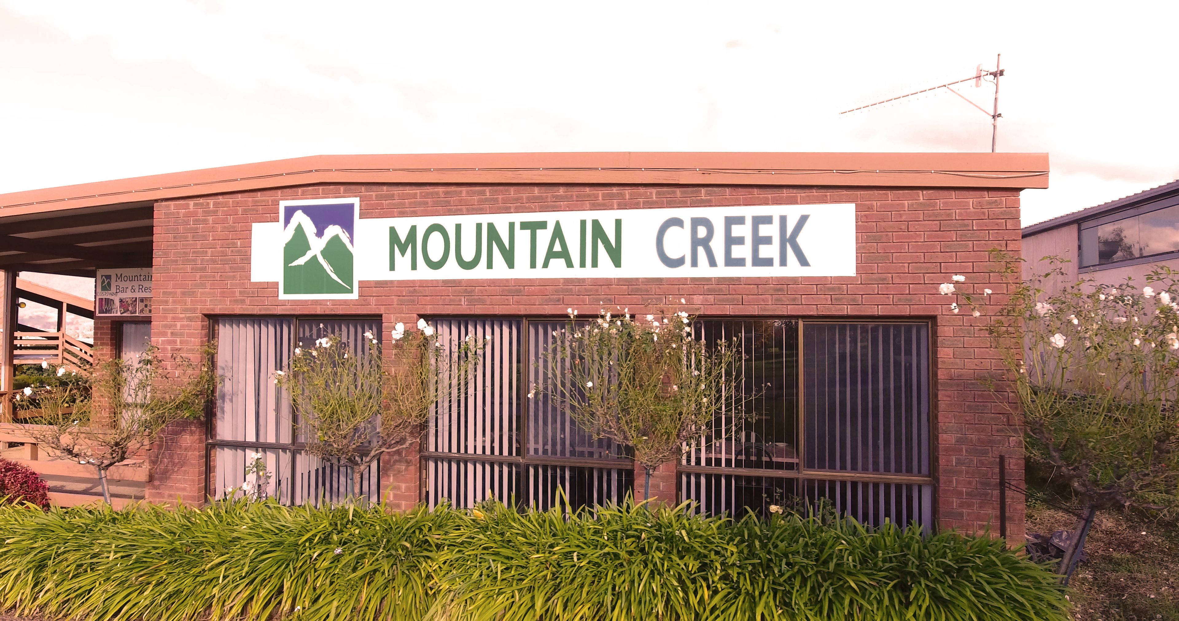 Un bâtiment sur lequel on peut lire l’inscription « Mountain Creek » et qui arbore un logo représentant une montagne.