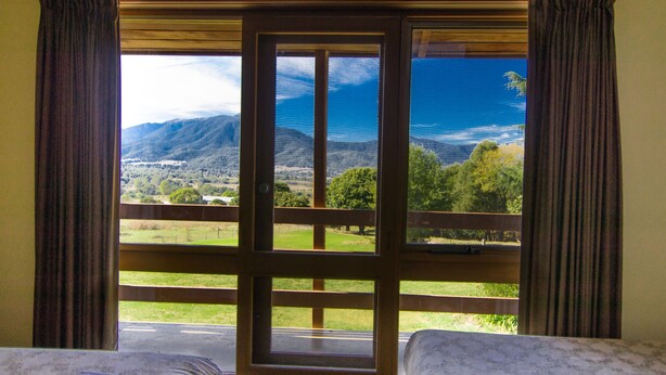Una habitación con un gran ventanal que ofrece vistas a un paisaje montañoso.