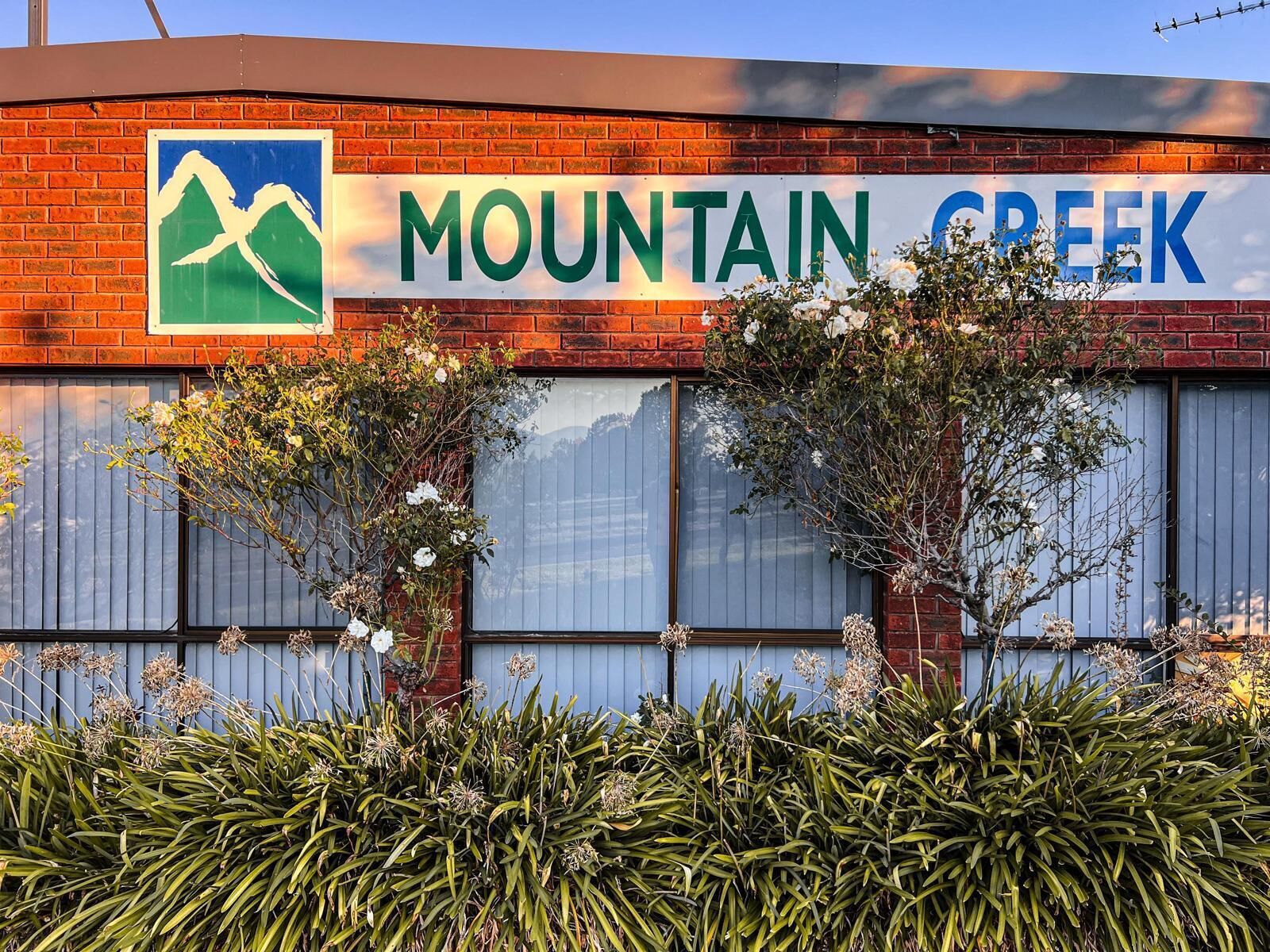 Un edificio con un letrero que dice "MOUNTAIN GREEK" y un gráfico de una montaña.