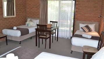 Una habitación con dos camas, una mesa de comedor y sillas.