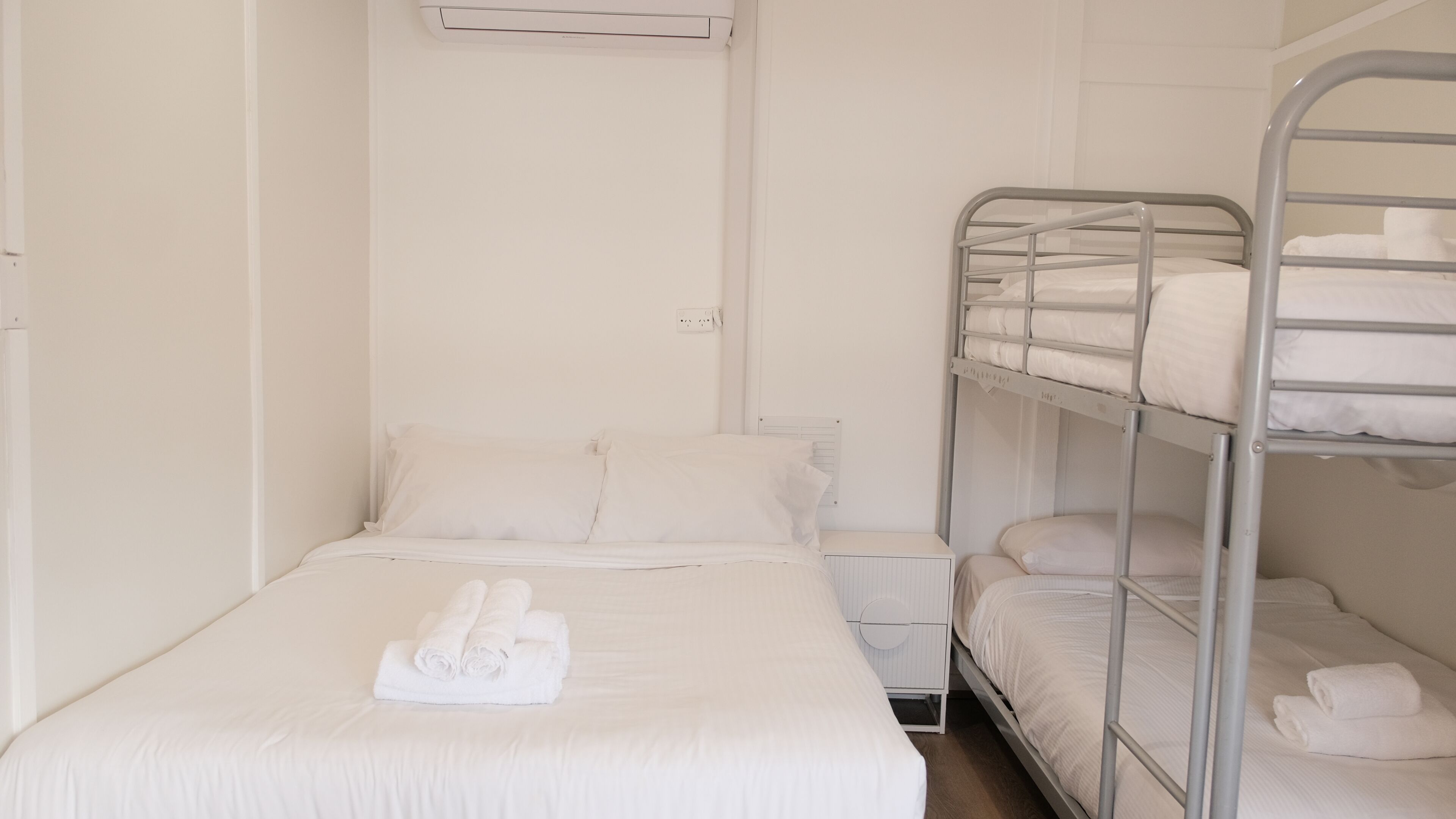 Habitación con literas, una mesita de noche y un radiador.