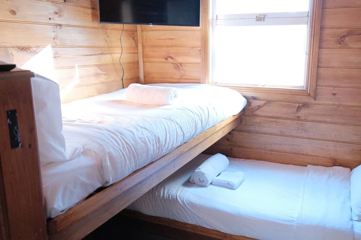 Small L shaped bunk room with shared bathroom